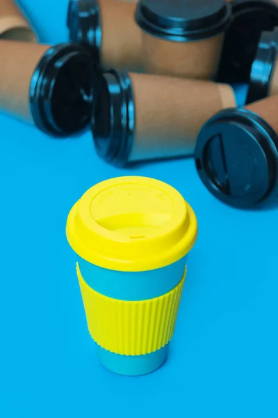 Stylish reusable eco coffee cup and multiple single use cardboard cups — Stock Photo, Image