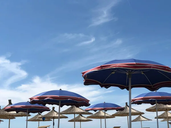 Wind waait. Strandblauwe parasols aan de Adriatische Zee in Albanië, Durres — Stockfoto