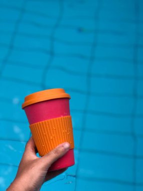 Yüzme havuzunda kahve içen bir kadın.