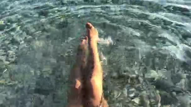 Female splashing water with her feet.hot summer day — Stock Video