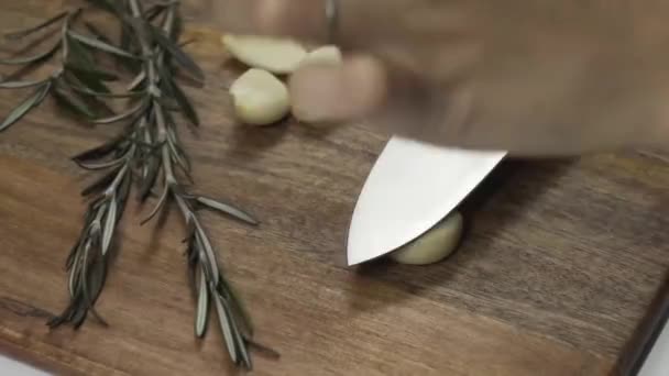 Close Woman Hand Crushed Clove Garlic Dark Brown Wooden Cutting — стоковое видео