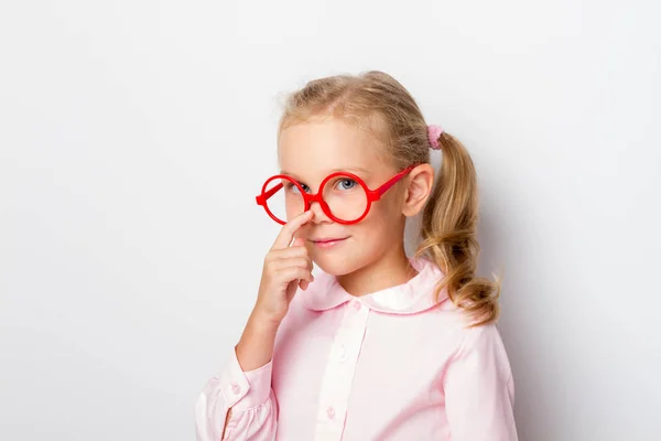 Una hermosa chica endereza sus gafas con su dedo —  Fotos de Stock