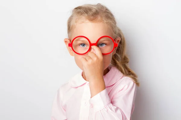 Uma linda garota endireita seus óculos com o dedo — Fotografia de Stock