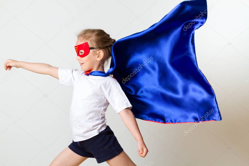 Funny little power super hero child in a red raincoat. Super hero concept.