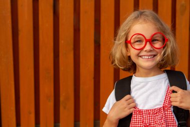 Mutlu sevimli zeki kız gözlük ile okul çantası