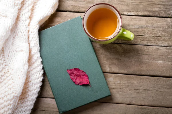 Fundo de outono em uma mesa de madeira com um xale de lã de malha — Fotografia de Stock