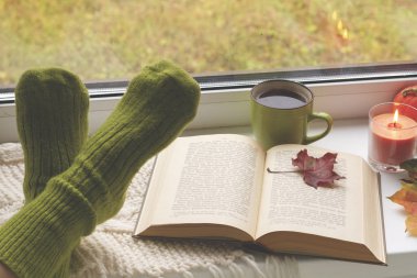Cozy kış natürmort: açılan kitap ve bacaklar