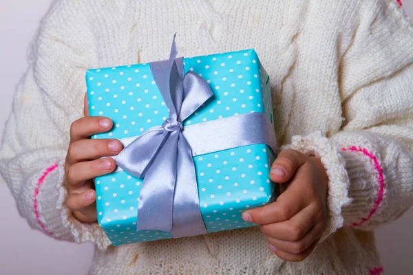 Caixa de presente azul bolinhas nas mãos da criança — Fotografia de Stock