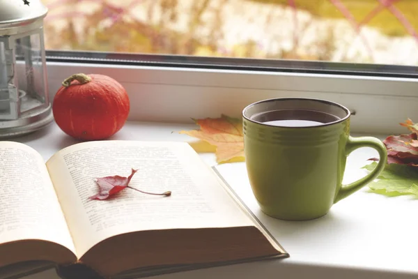 Outono ainda vida. livros, folhas, xícara e castiçal na janela . — Fotografia de Stock
