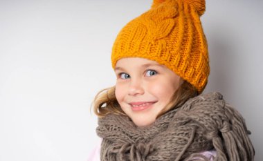 Örgü şapka ve atkı giyen dişlek gülümseyen genç kadın portresi yüz kadar kapatın. 