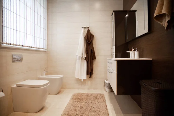 Jasne, nowe wnętrze łazienki ze szklanym spacerem pod prysznicem otaczają, brązowa szafka próżności i w połączeniu z płytką mozaikową . — Zdjęcie stockowe