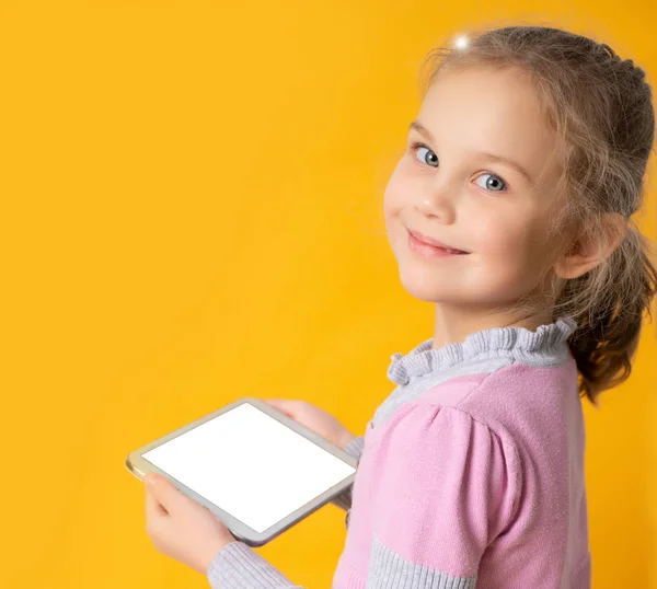 Chica feliz usando tableta, aislado sobre fondo naranja — Foto de Stock