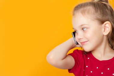 küçük kız 5 yaşında bir cep telefonu konuşuyor ve uzağa bakıyor, metin için yer