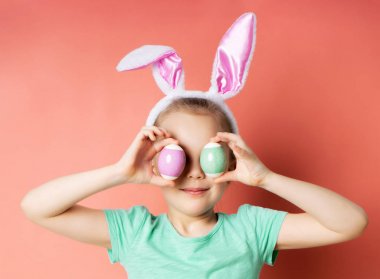 Gözlerinin önünde tavşan kulakları takan mutlu bir genç kızın stüdyo çekimi