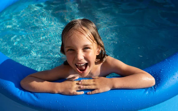 Sonriente linda niña en la piscina en el día soleado. —  Fotos de Stock