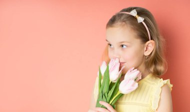 Pembe arka plan üzerinde izole lale büyük buket tutan elbise güzel bir genç kız portresi