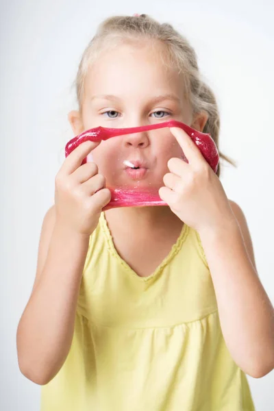 Menina alegre feliz jogando um lodo vermelho — Fotografia de Stock