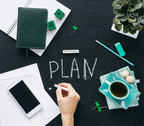 Top view on the desktop graphite stock. On the table is a notebook with a notebook, a cup of tea, canstovary, years, phone, calendar. — Stock Photo, Image