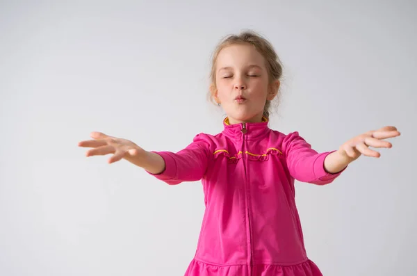 Ragazzina concentrata con gli occhi ben chiusi che gioca a fare magie alzando le mani con le palme aperte. Vita-up shot isolato su bianco, spazio copia — Foto Stock