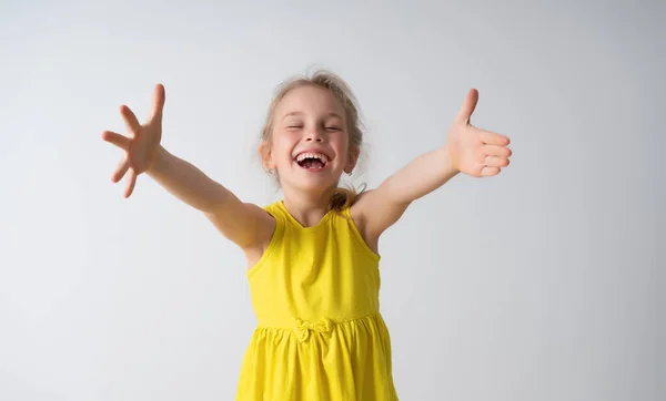 Happy little blonde girl in sunny yellow sleeveless dress extending her arms with laugh going to embrace someone. Waist-up portrait isolated on white — Stock Photo, Image