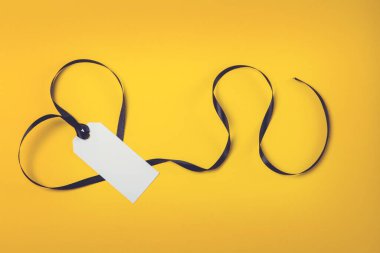 Sarı arka planda siyah kurdeleli beyaz etiket.