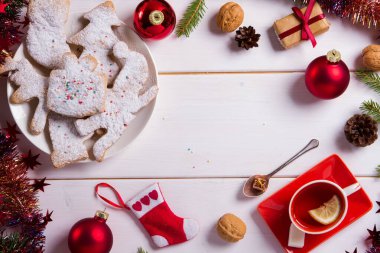 Noel tatlıları tabakta kurabiye pişiriyor. Noel kurabiyeleri, Noel tümsekleri için dekore edilmiş. Çay içeceğim. Yeni yıl yemeği. Kırmızı dekor. Üst görünüm