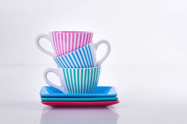 Kare dairelerde teke tek kahve şeritli üç renkli fincan.