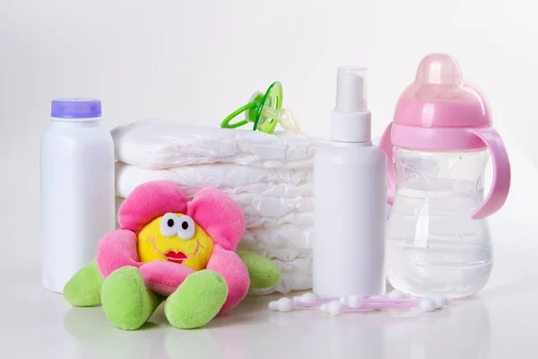 白色背景上堆放的婴儿即弃尿布和玩具 — 图库照片