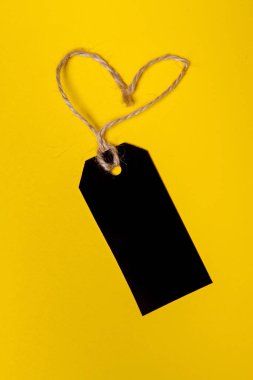  Sarı arka planda kalp şeklinde alışveriş etiketi kavramı