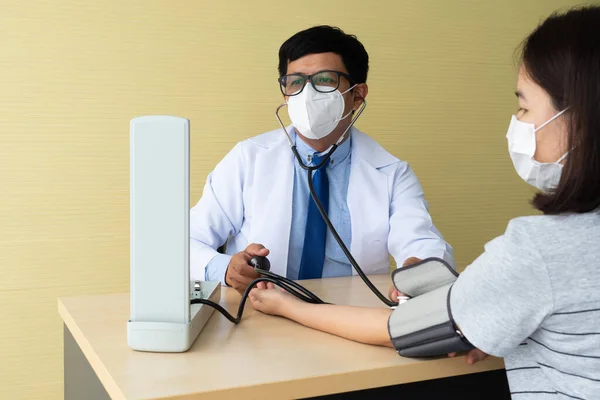 Asiatischer Arzt Mit Blutdruckmessgerät Den Blutdruck Der Patientin Mit Bluthochdruck — Stockfoto