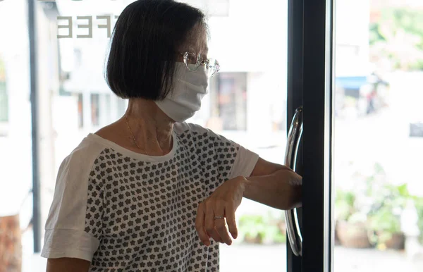 コーヒーショップの扉を開くために肘を使用してマスクを身に着けているシニアアジアの女性は Covid 10やコロナウイルス感染を防ぐために 社会的距離と新しい通常の概念は — ストック写真
