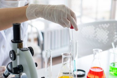 Korumalı ekipman ya da mikroskop kullanarak laboratuarda kovid-19 ya da koronavirüs aşısı deneyi yapan bilim adamlarının fotoğrafını çek. Bilim ve Tıp Konsepti