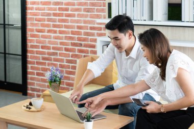 Genç Asyalı bir adam kafede meslektaşı ile çalışmak için bilgisayar kullanıyor. iş ve uzaktan çalışma kavramı