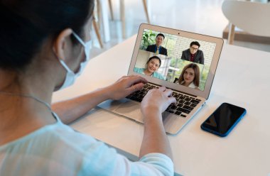 Asyalı iş kadını, Coperid-19 ya da Coronavirus salgını sırasında müşterileriyle video konferansında çalışmak için bilgisayar kullanıyor. teknoloji ve iş kavramı