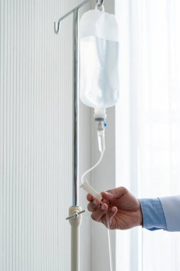 Doktor, Asyalı kadın hastaya damar içi sıvı veriyor. Hasta olduğu için hastaneye yatırılmış. Sağlık ve tıbbi konsept (doktorun sağ eline odaklanın)