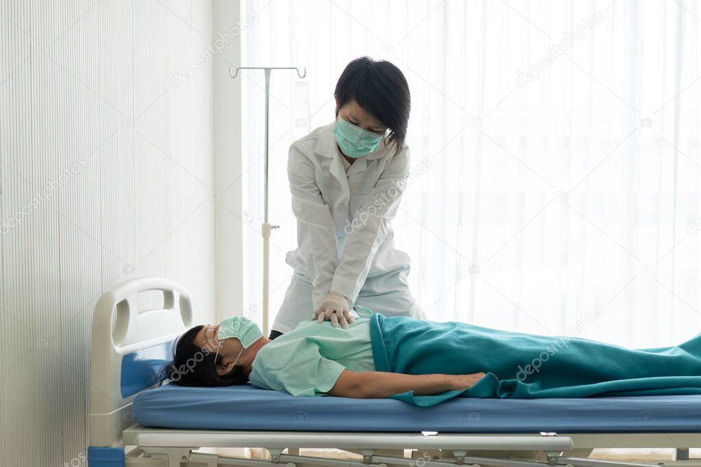 doctor wearing gloves doing cardiopulmonary resuscitation or cpr to help asian senior patient who has cardiac arrest in hospital. healthcare and medical concept