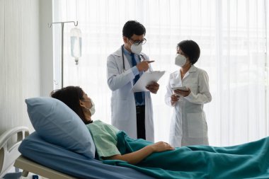 Hastanedeki hasta hastaları tedavi etmek için maske takan Asyalı doktor öğretiyor. Sağlık ve Tıp Fakültesi kavramı