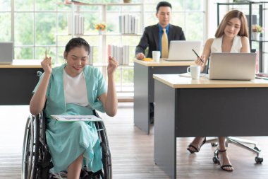 Tekerlekli sandalyede oturan ve bilgisayarla iş arkadaşlarıyla proje tartışan Asyalı engelli genç bir kadın. engelli ve engelli kavramı