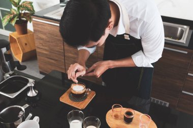 Restoranda sanat latte 'si yapan genç Asyalı adam. Kahveci ve kafe konsepti