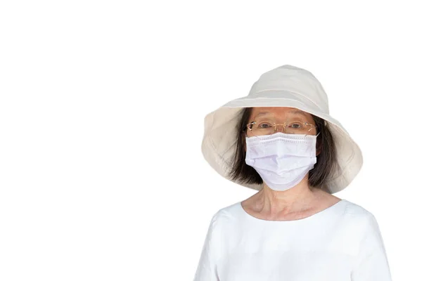 白い背景にフェイスマスクと帽子を被ったアジア系のシニア女性 — ストック写真