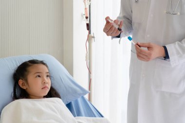 Hastane pediatri koğuşunda, Asyalı doktor test için genç kızdan kan alıyor. Sağlık ve Tıp Konsepti