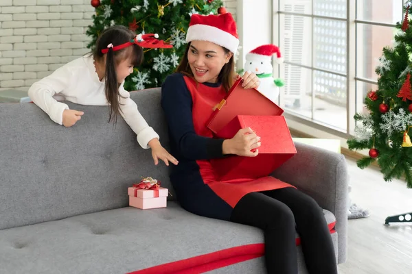 mother gives presents to her young daughter in christmas holliday. family together and relationship concept