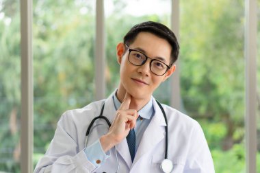 Genç Asyalı doktor, video konferansı yoluyla hastaya karotid nabzı nasıl değerlendireceğini gösteriyor. teletıp ve online tıbbi konsept