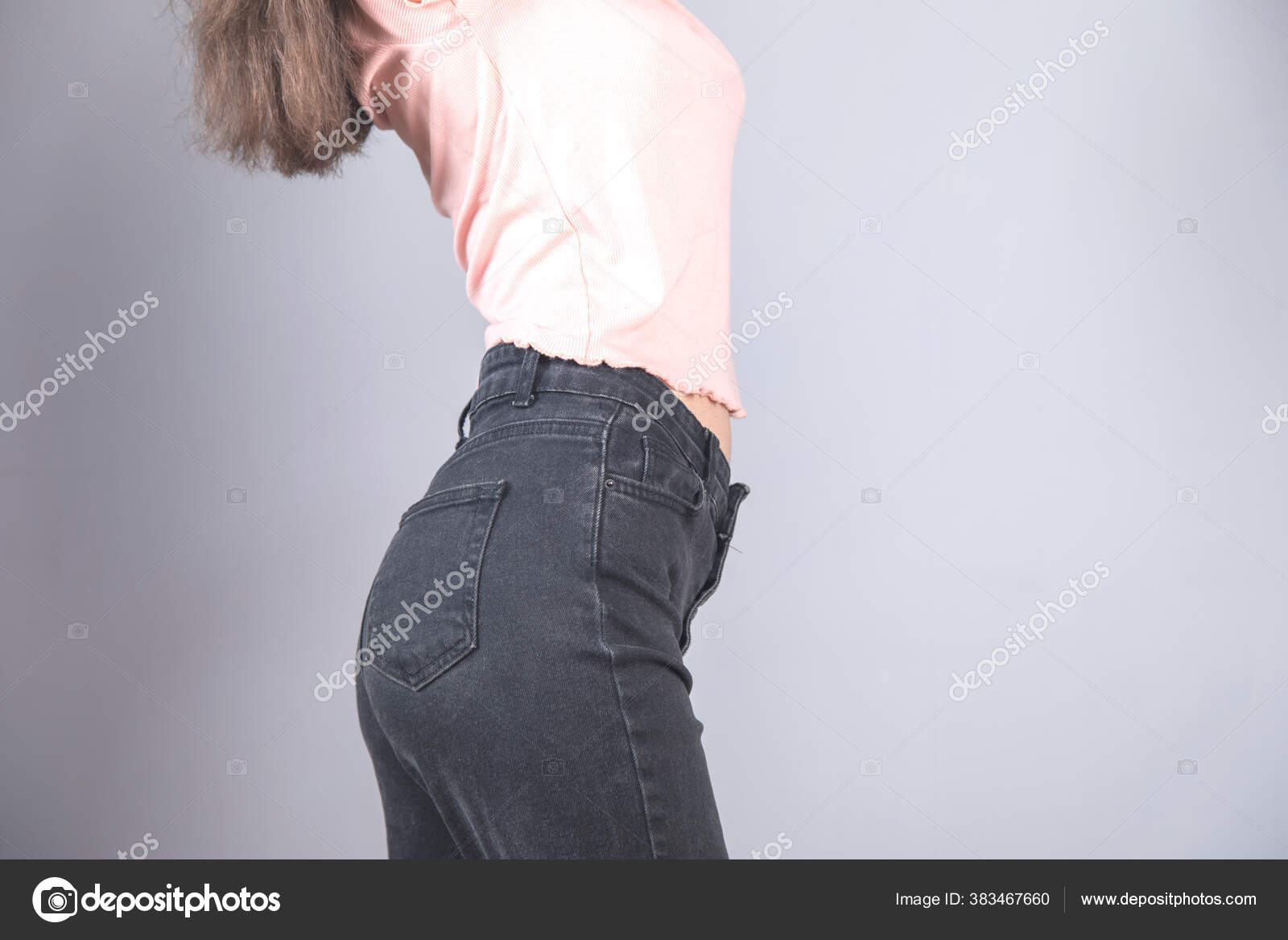 穿着灰色背景牛仔裤的性感女人 图库照片 C Aghavni 穿着灰色背景牛仔裤的性感女人 图库照片 C Aghavni