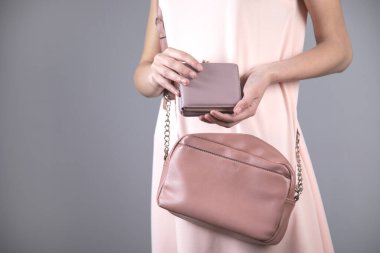 Gri arka planda kadın el cüzdanı ve çanta