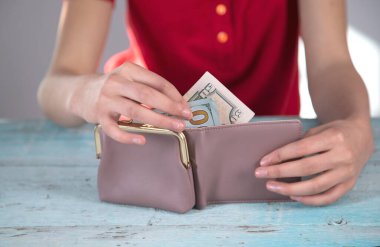 Kadın el parası ve cüzdanı masa arkasında.