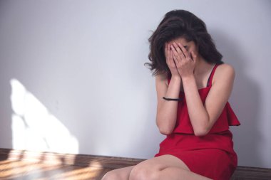 Genç üzgün kadın yerde oturuyor. 