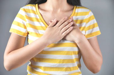 Gri arka planda el ele mutlu bir kadın