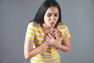 Gri arka planda acı çeken bir kadın.