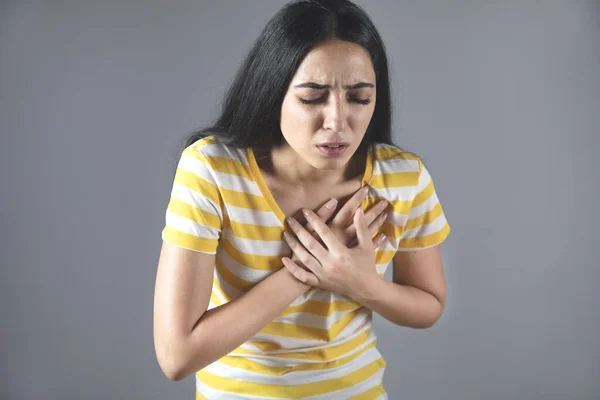 woman hand in ache heart on grey background